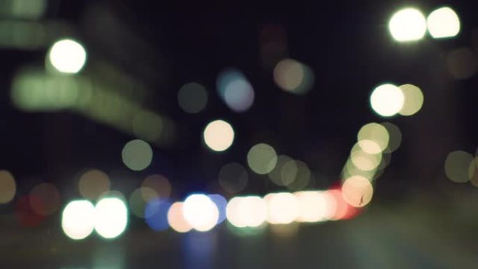 模糊，焦点不集中，夜间的Bokeh城市灯光。发光的移动车灯和交通，用于屏幕更换和背景拼贴。温暖的氛围