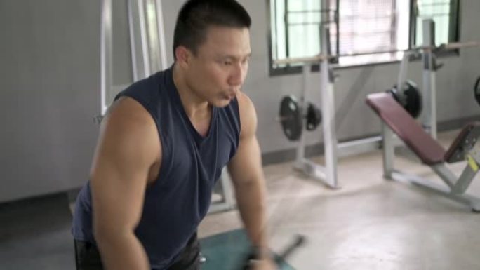 在健身房锻炼肌肉的亚洲男子