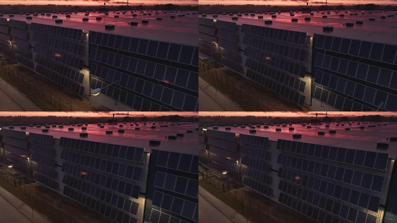 航空移动平行镜头，多个现代太阳能电池板连接到物流大楼的工业仓库。黄昏黄昏日落，云彩轻盈，粉色。