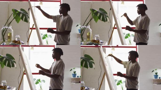 非裔美国男性艺术家在艺术工作室画布上绘画的侧视图
