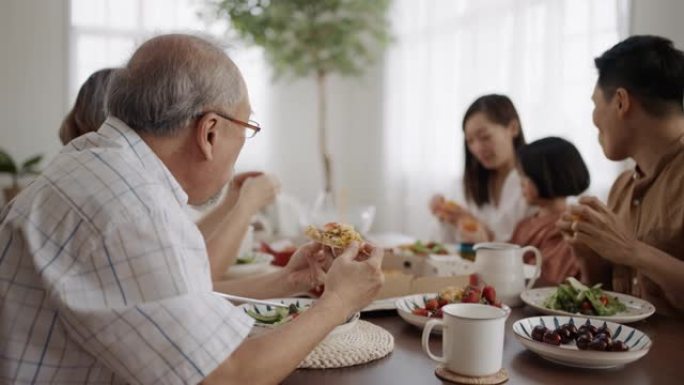 快乐的亚洲家庭在家里的餐桌上一起享用午餐