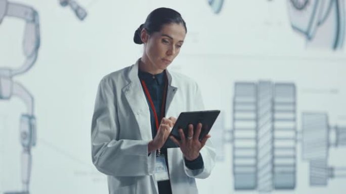 在开发实验室中: 使用数字平板电脑穿着白大褂的美丽首席女工程师的肖像。背景大屏幕显示高科技工业和医疗