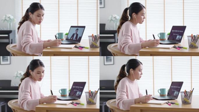 侧视图年轻的亚洲女性听观看数字课程在线学习员工技能在家庭办公室的笔记本电脑上提高技能。针对成人的商学