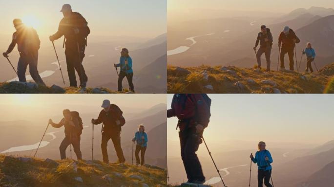SLO MO三个徒步旅行者在日落时走在山脊上