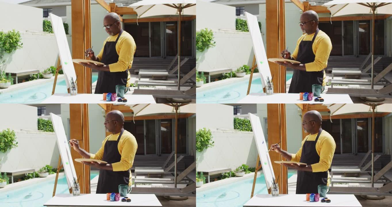 非裔美国高级男子站在露台上画画