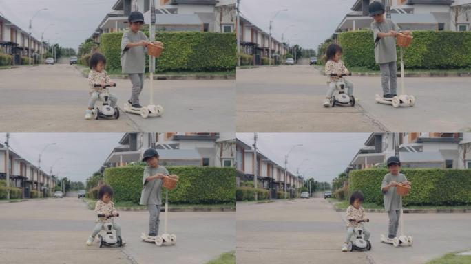 小男孩和他的妹妹骑着一辆踏板车。