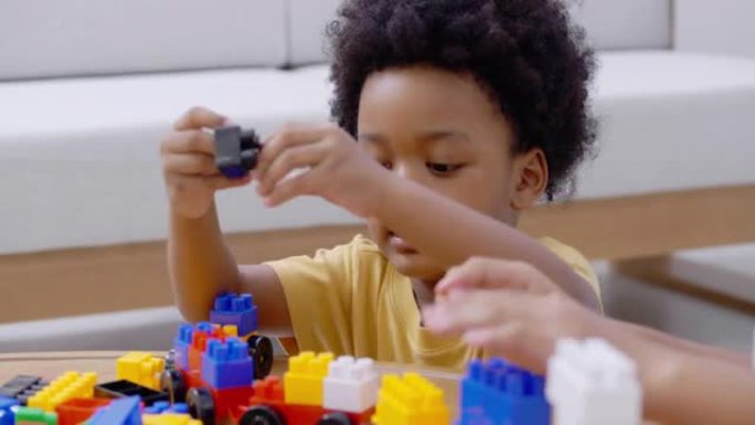 肖像非洲种族的小男孩和女孩，年龄3,9岁，在家里上学的时候玩五颜六色的玩具块，呆在家里，以防止家庭生