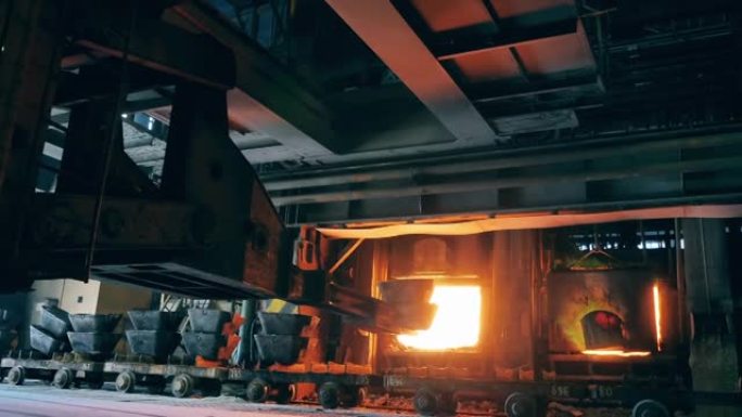 具有工业机械的铸造炉将金属装入其中