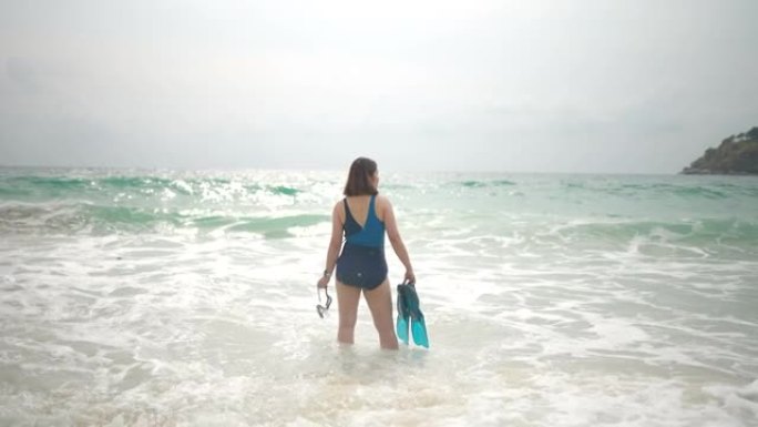 穿着泳衣的女人在海滩上穿着泳衣，在假期里浮潜