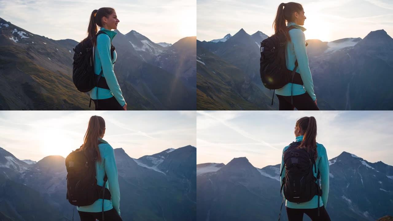 女人站在山顶上，在日落时欣赏周围山脉的壮丽景色