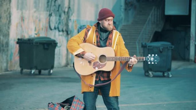 一个无家可归的人在街上弹吉他
