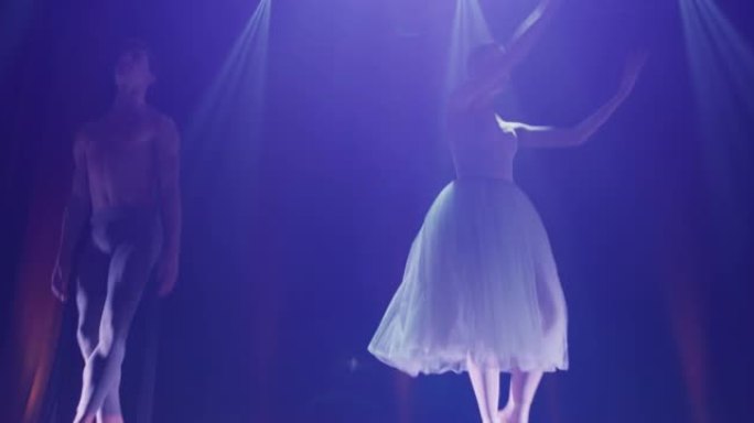 年轻的古典芭蕾舞演员夫妇的电影镜头在演出开始前在经典剧院舞台上表演舞蹈。
