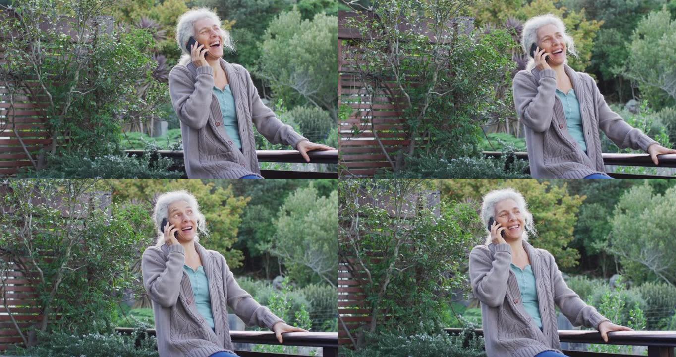 高级混血女子在阳台上智能手机上聊天的肖像