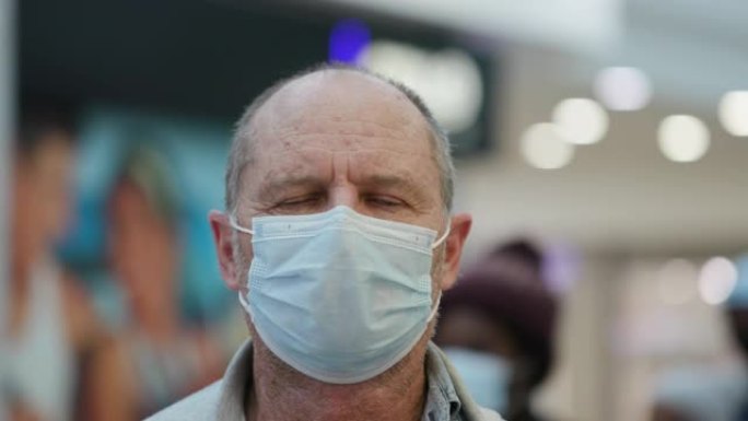 购物中心一名戴着防护口罩的高级男子的特写肖像图，以防止新型冠状病毒肺炎冠状病毒大流行