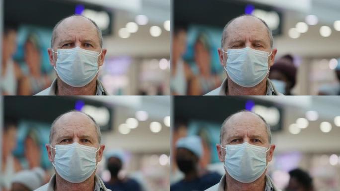购物中心一名戴着防护口罩的高级男子的特写肖像图，以防止新型冠状病毒肺炎冠状病毒大流行