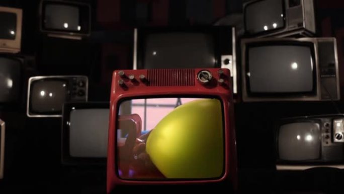 黄色氦气球在复古电视上爆炸。