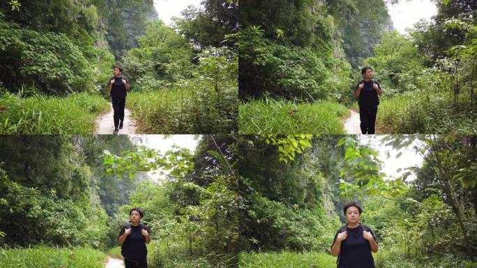 一名亚洲中国中年女性旅行徒步旅行，用背包探索怡保霹雳州马来西亚森林