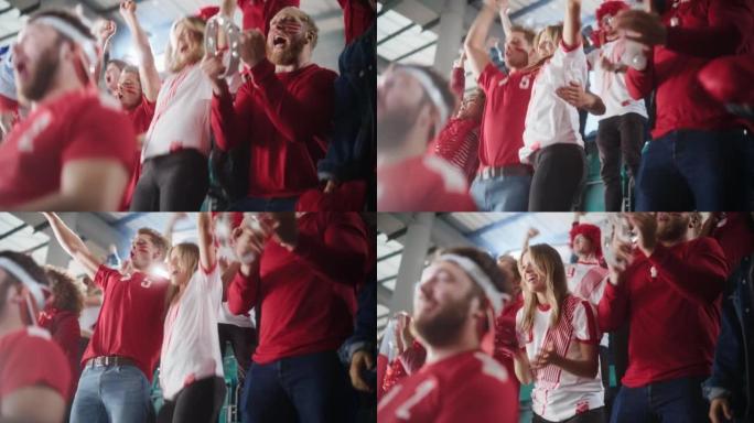 体育馆大事件: 一群球迷为红色足球队获胜而欢呼。人们庆祝进球，冠军胜利。可爱的白种人夫妇，脸上涂着脸
