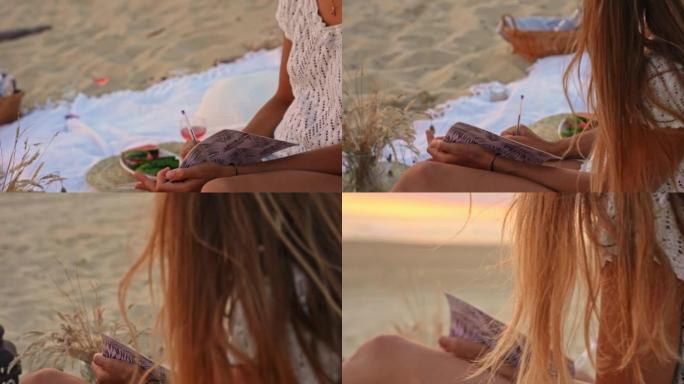 年轻女子女士在日落时在沙滩上写日记
