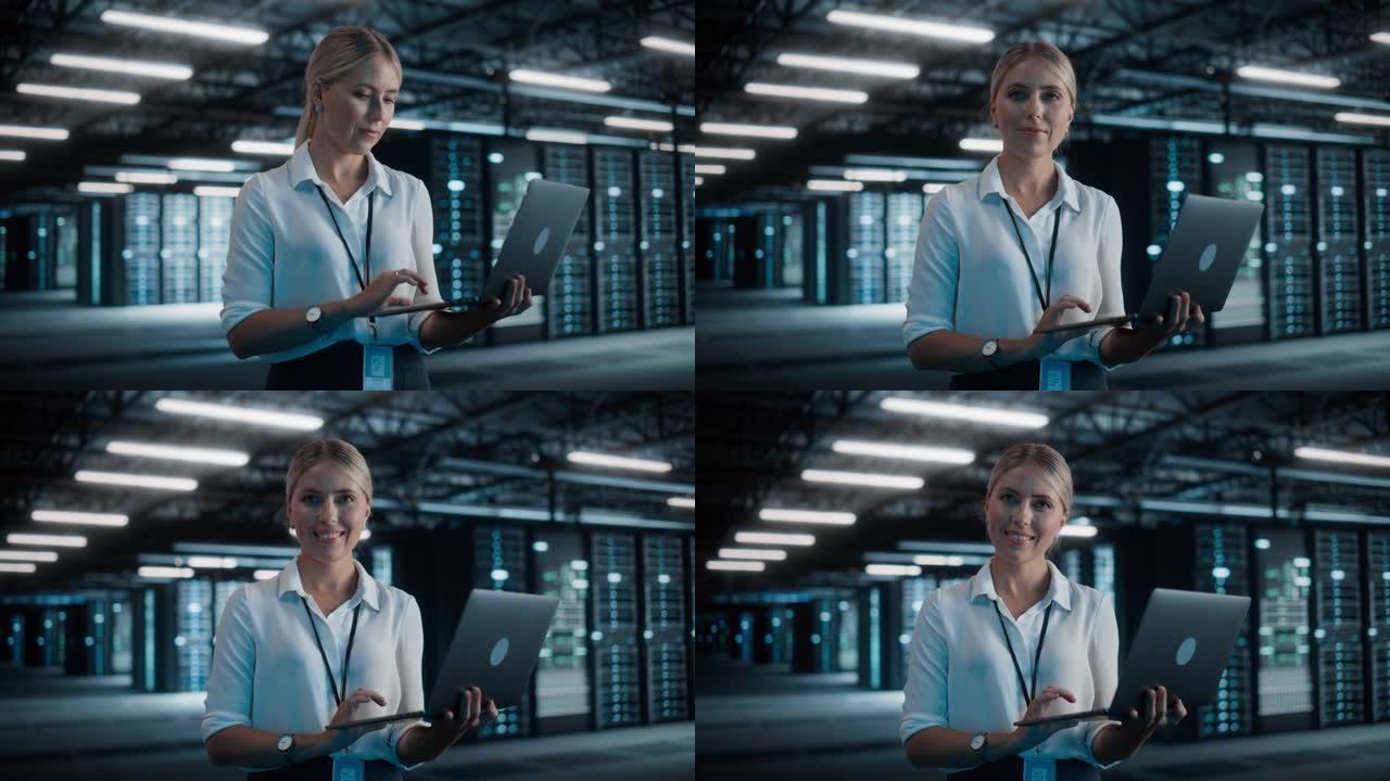 成功的女性首席技术官的肖像使用笔记本电脑，站在大仓库数据中心，看着相机。SAAS、云服务服务器的系统