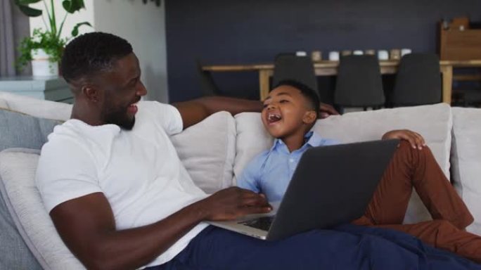 非裔美国人父子一起使用笔记本电脑
