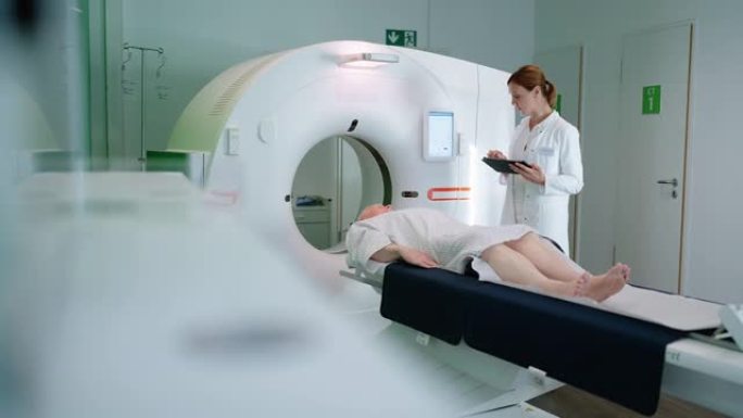 医生与临床上进行MRI扫描的高级男性患者交谈