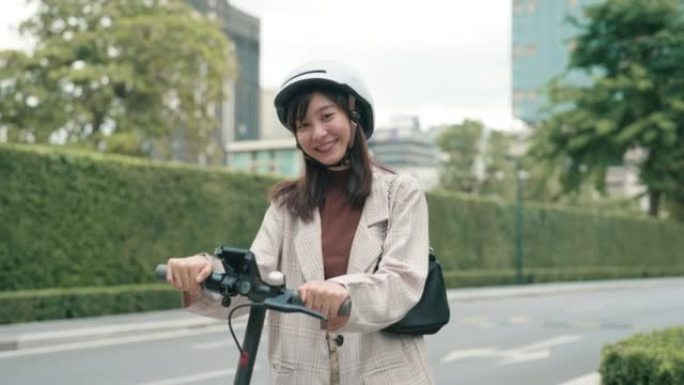 亚洲女商人乘坐踏板车出差的肖像。