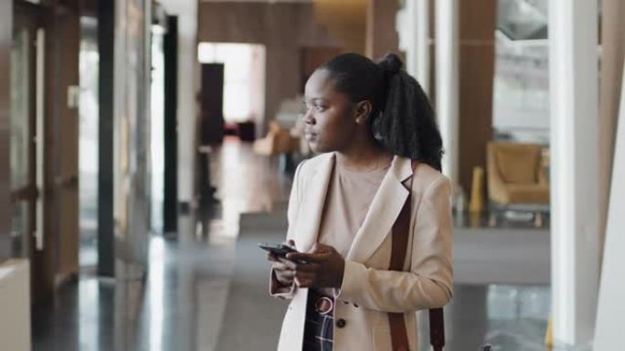 年轻的黑人妇女在智能手机上发短信