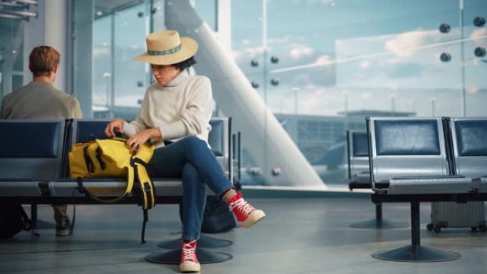 机场航站楼: 黑人妇女等待航班，使用智能手机，收到令人震惊的坏消息，错过航班。坐在航空枢纽的登机休息