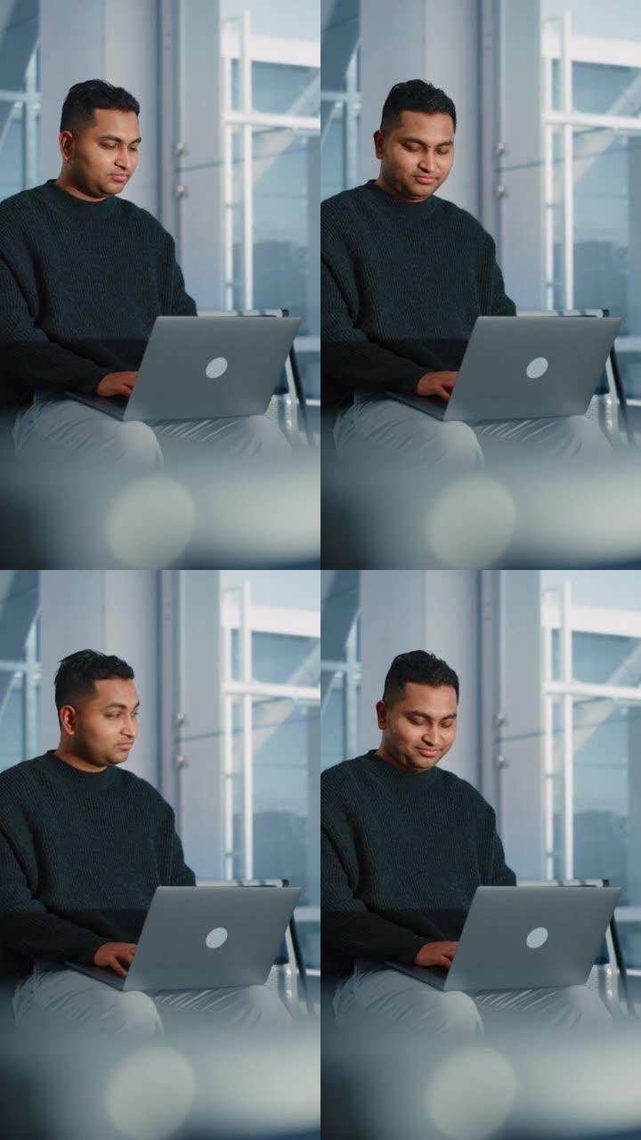 垂直屏幕。机场航站楼: 印度商人使用笔记本电脑，等待他的航班。坐在航空枢纽登机休息室的旅行数字企业家
