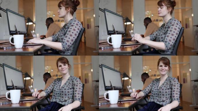 一个自信的女商人坐在创业办公室的办公桌前的肖像