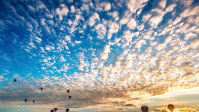 日出时热气球飞越卡帕多西亚山谷。空中无人机的观点。戏剧性的晨光