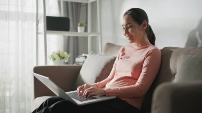 亚洲妇女的多莉在家里使用笔记本电脑