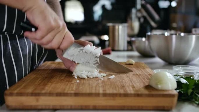 特写厨师用手在砧板上用刀将白洋葱切成薄片。木板上的新鲜蔬菜。厨师在家准备食物。沙拉传统厨房4k的健康