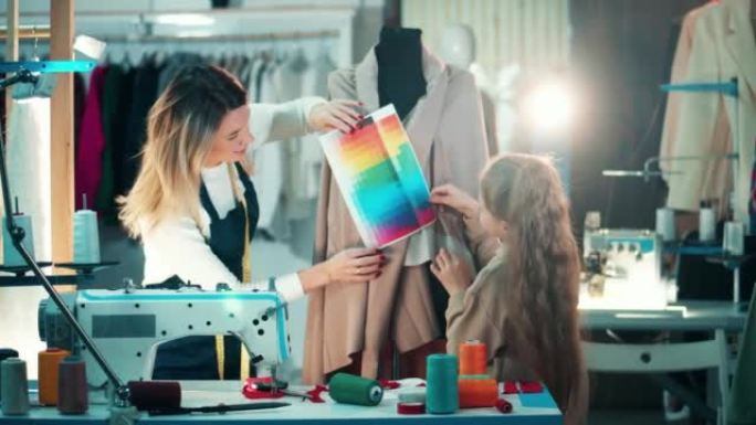 一个女裁缝和一个女孩正在裁缝中研究颜色