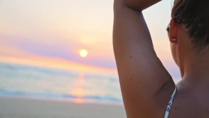 年轻女子女士在日落时在海滩上的头发上奔跑