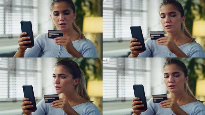 金发碧眼的年轻女子的真实照片正在使用智能手机输入信用卡信息，同时在家里的客厅在线购物。