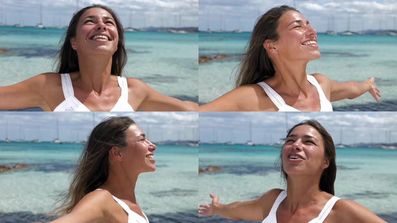 一个自然美丽的女人穿着白色夏装在海滩上享受一天的真实照片。女性旅行者在阳光下度假时尖叫和庆祝