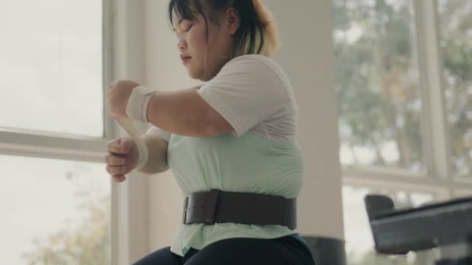 适应性亚洲女运动员准备在健身房锻炼