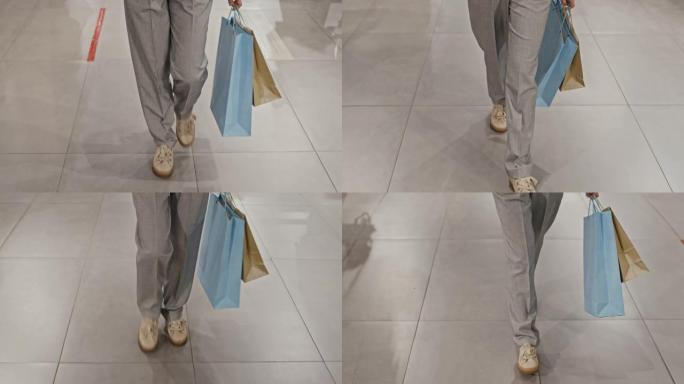 沿着购物中心散步的女人的腿