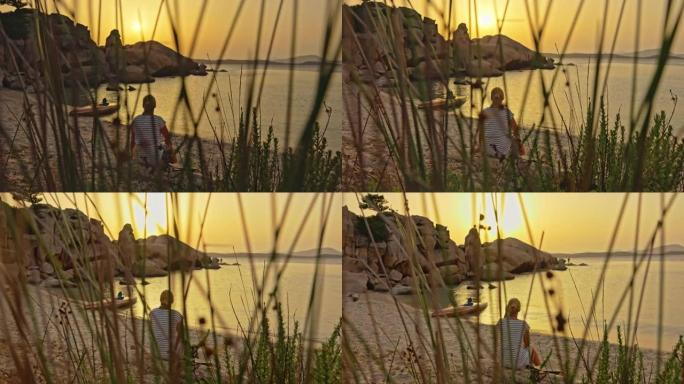 坐在海滩上的金发女孩的景色，撒丁岛，意大利。