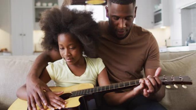 African american father and his daughter sitting o