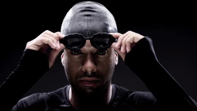 4k录像片段，一名年轻男子在黑色背景上戴着游泳镜