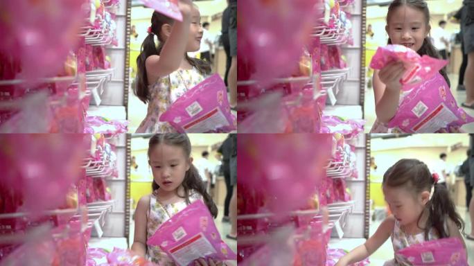 可爱的小女孩在超市的玩具部门购买玩具