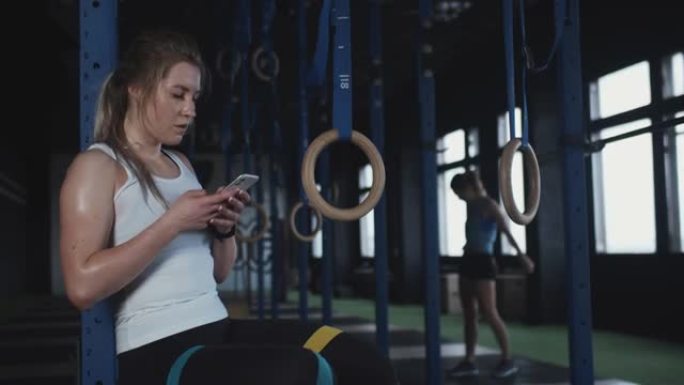 利用科技实现健身目标。美丽健康的女人上传健身活动到健身房的智能手机手机应用程序