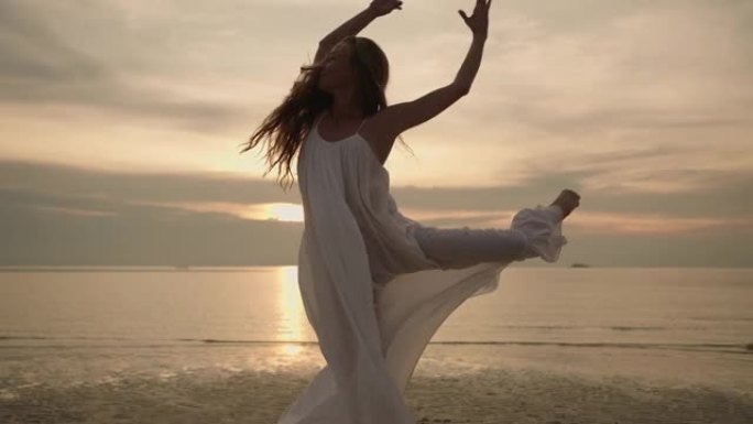 日落时在海滩上跳舞的女人
