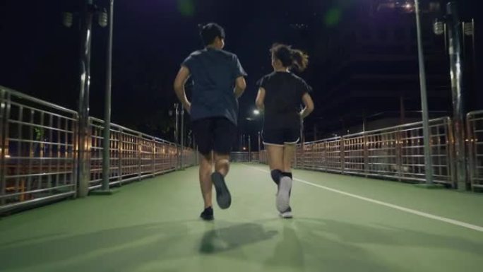 年轻男女跑步。情侣夜跑背影视频素材