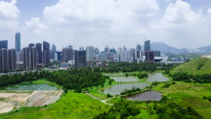 香港与中国深圳天际线之间的带有鱼塘的乡村绿地景观