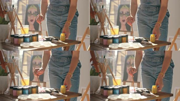 艺术家在她的家庭工作室中在木制调色板上混合油或丙烯酸涂料的特写镜头。才华横溢的女人，富有创造力的画家
