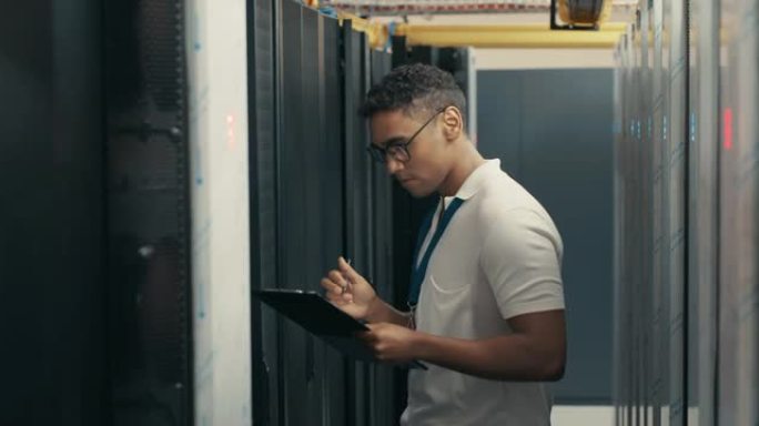 一个英俊的年轻技术人员在服务器机房进行维护检查时使用剪贴板的4k视频片段